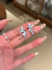 Vue détaillée de boucles d'oreilles fleuries bleu clair avec cristaux