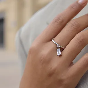 Detailopname van een roestvrijstalen ring met een hangende rechthoekige zirkoon.