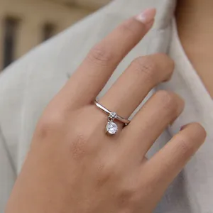 Detailopname van een roestvrijstalen ring met een sprankelende zirkonia-hanger.