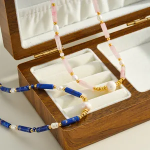 Vue détaillée de colliers en acier inoxydable avec perles et cylindres de pierre colorés.