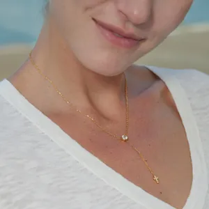 Close-up of a premium gold 18k plated Y-necklace with round zircon and cross charm