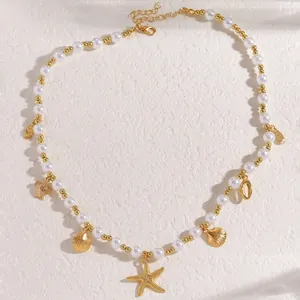Dettaglio di ciondoli a stella marina e tartaruga su collana di perle da spiaggia