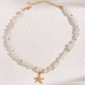 Dettaglio della collana stella marina con pietre bianche e perle dorate su pietra