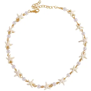 Dettaglio della collana con stelle marine e perle con catena dorata e chiusura a moschettone