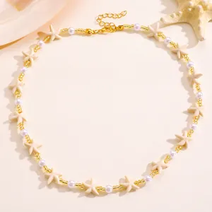 Close-up of ocean-style beaded necklace with gold beads, pearls and starfish charms