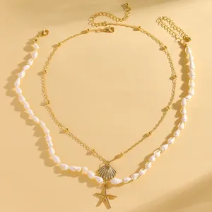 Dettaglio di collana dorata a strati con conchiglie naturali e ciondoli a stella marina