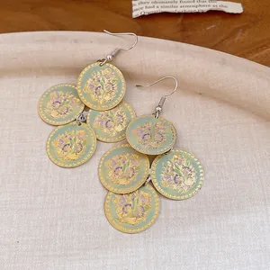Vista detallada de pendientes redondos vintage verde menta con motivos florales dorados