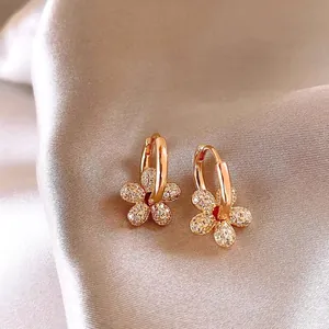 Gros plan sur les boucles d'oreilles fleurs plaquées or 14 carats avec zircons brillants