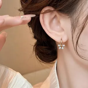 Vue détaillée de boucles d'oreilles créoles fleurs en zircon plaqué or 14 carats.