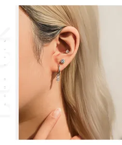 Detailansicht der funkelnden Moissanit-Ohrstecker aus S925-Silber am Ohr eines Models.