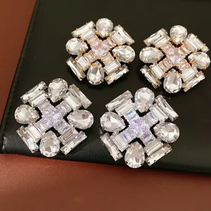 Macro view of luxurious statement earrings featuring clear pear and rectangular cut stones.