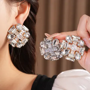 Detailed close-up view of exaggerated rhinestone stud earrings with clear zircon crystals