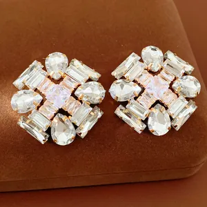 Detailed close-up of luxury geometric stud earrings featuring clear multi-faceted cubic zirconia
