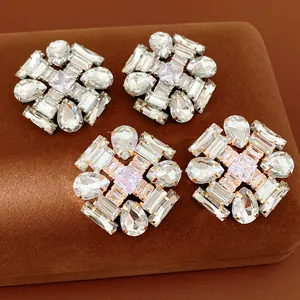 Macro view of luxurious zircon stud earrings featuring teardrop and emerald cut stones