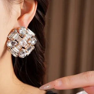 Close-up of exaggerated geometric stud earring with clear teardrop and zircon stones.