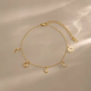 Detail view of 18k gold plated stainless steel anklet with star and moon charms.