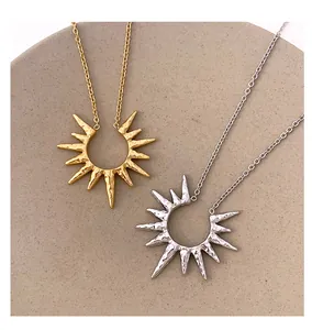 Dettaglio di pendenti a sole traforati con texture martellata in finitura oro e argento