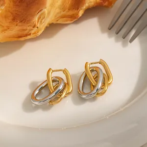 Detailed shot of two-tone 18K gold plated stainless steel U-shaped link earrings on a plate