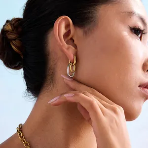 Close-up of minimalist two-tone U-shaped interlocking earrings on a model