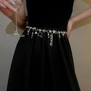 Nahaufnahme der silberfarbenen Taillenkette mit Sternen und Perlen am schwarzen Kleid