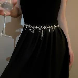 Detailaufnahme einer eleganten goldenen Taillenkette mit Strass, Perlen und Sternen.
