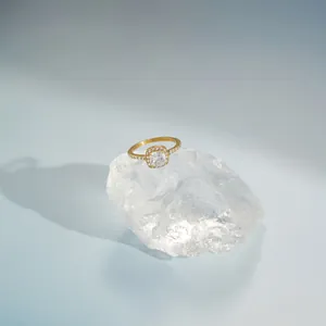 Close-up macro shot of a gold cushion-cut zircon ring placed on a crystal quartz background.
