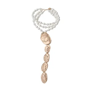Collier de perles à plusieurs rangs avec pendentifs ovales dorés froissés.