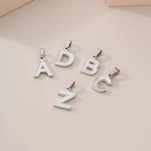 Elegant stainless steel initial pendants with white shell inlay on a beige backdrop