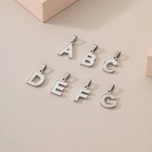 Mother of pearl inlaid stainless steel alphabet pendants A-G on neutral background