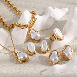 Vue détaillée d'un ensemble de bijoux dorés 18 carats avec perles baroques blanches