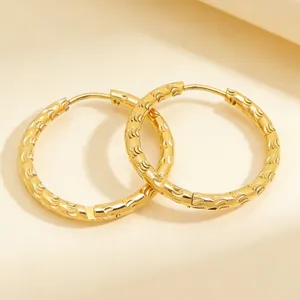Close-up of 18K gold plated stainless steel hoop earrings with textured scale pattern