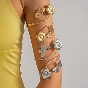 Eleganti bracciali da braccio in oro e argento con fiori e farfalle su una modella