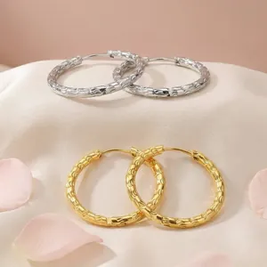 Detailed view of gold and silver textured 18K gold plated stainless steel hoop earrings