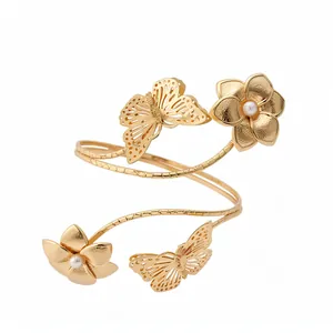 Elegante bracciale da braccio a spirale dorato con farfalle e fiori di perle su sfondo bianco