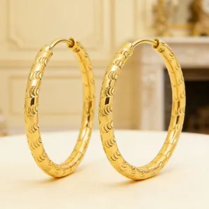Close-up of 18K gold plated stainless steel hoop earrings with textured pattern.