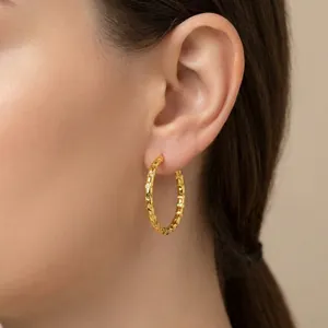 Detailed macro view of an 18K gold plated stainless steel hoop earring with textured finish
