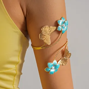 Vista dettagliata di un elegante bracciale da braccio dorato con fiori blu e farfalle