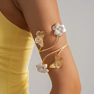 Dettaglio del bracciale da braccio a spirale dorato con farfalla e fiori di perla