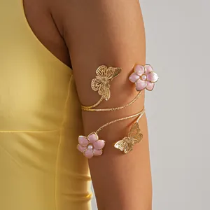 Dettaglio di un elegante bracciale da braccio dorato con fiori in smalto rosa e farfalle