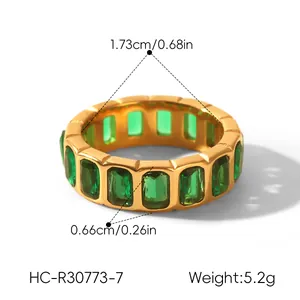 Detail view of gold stainless steel ring with emerald green zircons and measurements.