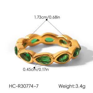 Detailed macro shot of gold stainless steel ring with green teardrop stones and measurements.