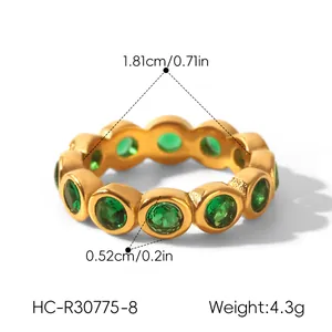 Macro view of gold stainless steel ring with green zircon stones and measurements