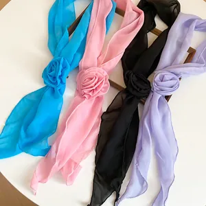 Macro view of elegant chiffon scarves with 3D fabric flowers in multiple colors.
