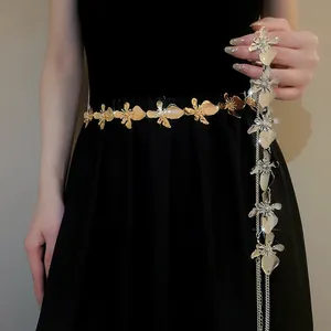 Detailed view of an elegant vintage golden metal flower waist chain on a black dress