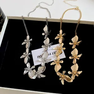 Close-up detail of vintage style gold and silver metallic flower waist chain necklaces