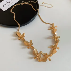 Close-up of an elegant vintage style gold metal floral necklace on a white background