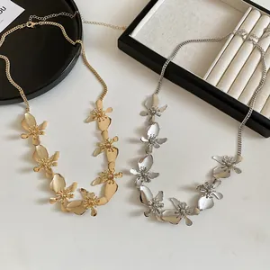 Detailed view of vintage gold and silver metal flower necklaces on a jewelry tray