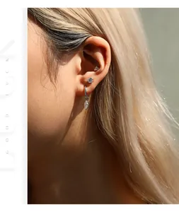 Professional close-up view of a model wearing Moissanite sterling silver ear studs and hoops
