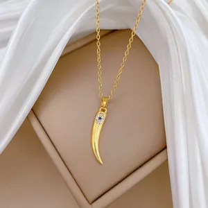 Detailansicht einer goldenen Titanstahlkette mit einem Kristall-Böser-Blick-Hornanhänger.