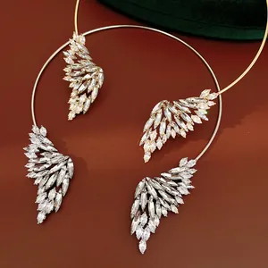 Gros plan des colliers ras de cou ailes d'ange en cristal argenté et doré de luxe.